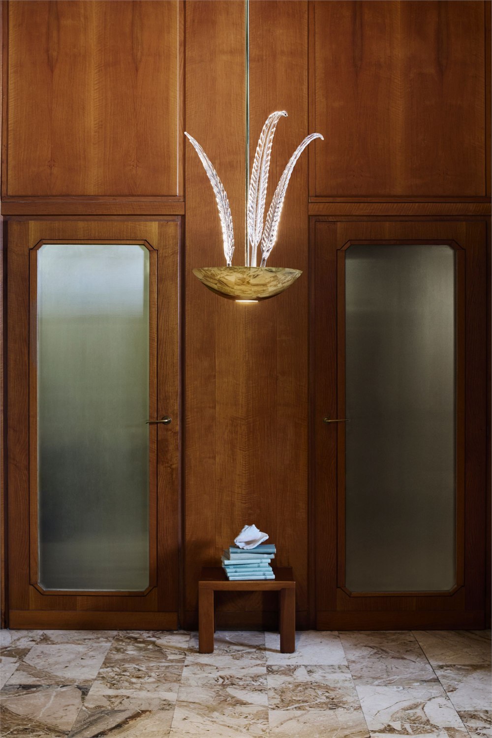 Garden Paradise pendant with handmade clear glass leaves in a wood paneled interior