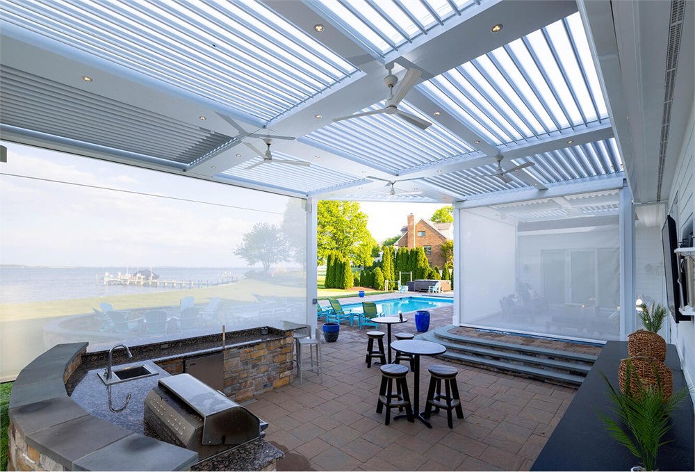 Outdoor patio covered by a StruXure louvered pergola with fans and screens