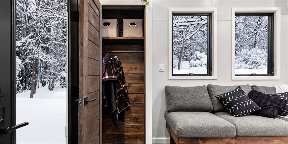 Wood stove and seating area inside The Retirement Retreat tiny house