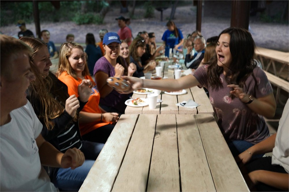 People playing Shocktato hot potato party game at a picnic table
