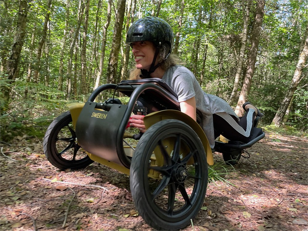 Sweren Swerv off-road electric trike with rider in a wooded setting