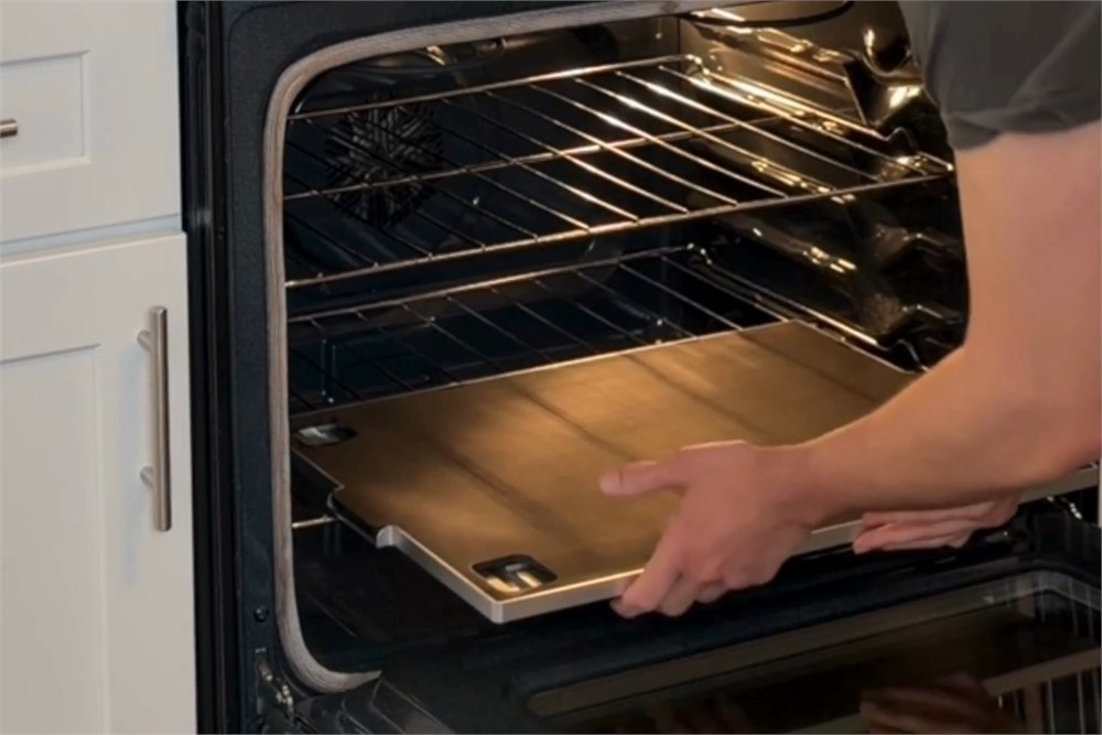 U Steam metal steam injection tray being placed inside a home oven