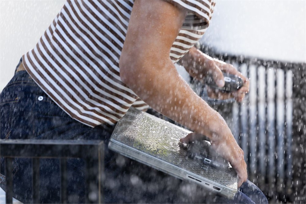 Damp laptop shown outdoors in a rain recovery context