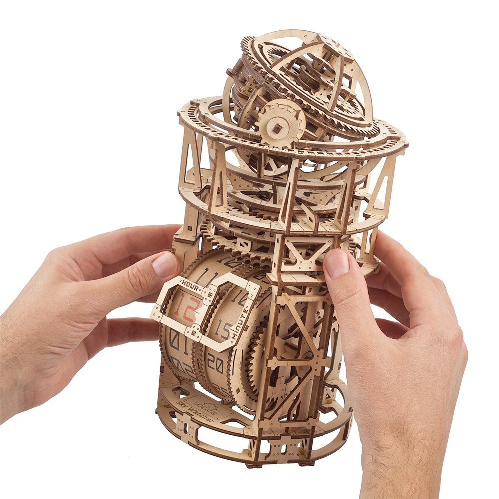 Hands holding the assembled UGEARS Astronomer wooden tourbillon table clock