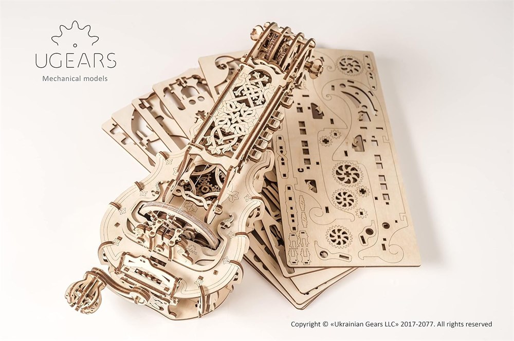 UGEARS hurdy-gurdy kit parts laid out with the assembled wooden instrument
