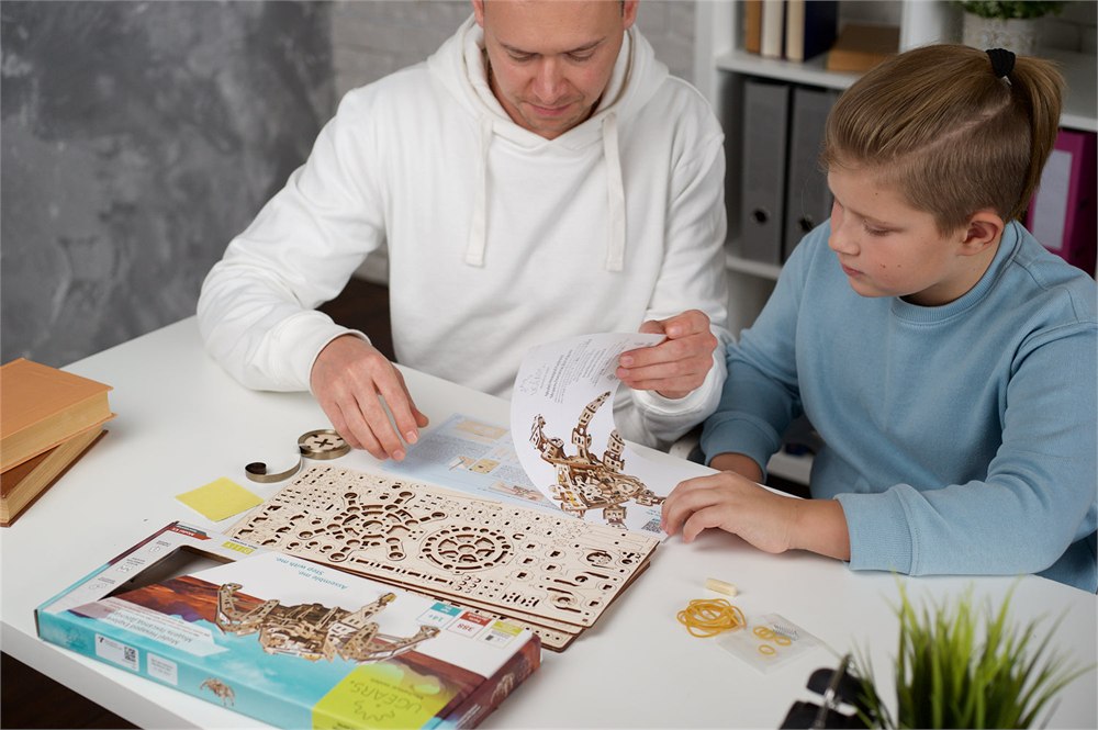 UGEARS wooden hurdy-gurdy model kit displayed on a table