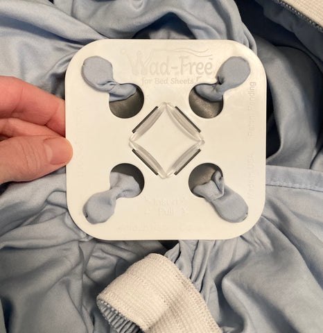 Close-up of Wad-Free clipped onto a light blue fitted sheet