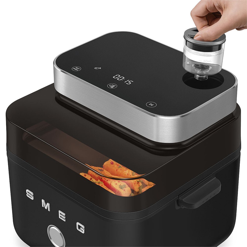 Hand lifting the small water reservoir from the air fryer top