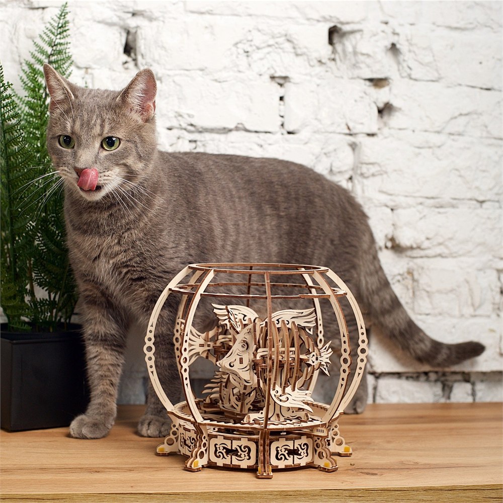 Wooden mechanical aquarium displayed beside a cat
