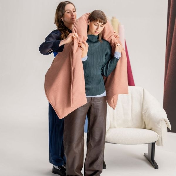 Designers demonstrate the jacket-like upholstered chair cover