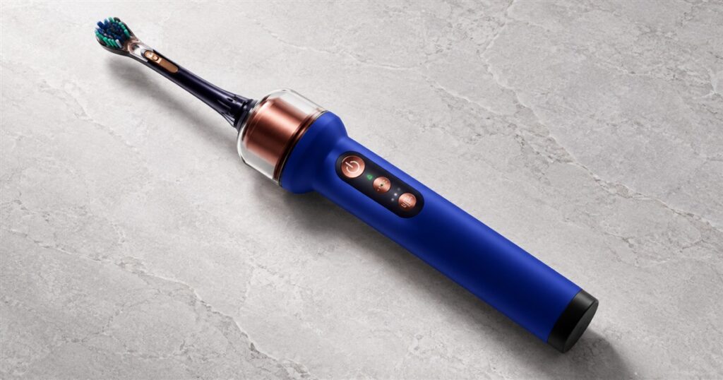 CameraJet camera-guided flossing toothbrush on a light studio surface
