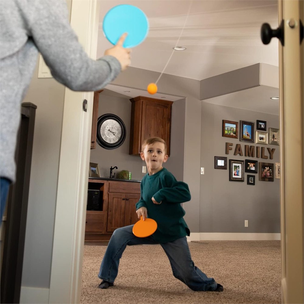 Kids playing Door Pong in a home doorway with paddles