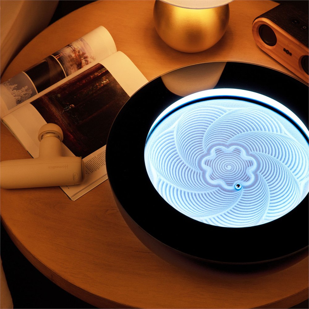 Black HoMedics Drift with blue illumination on a wood table
