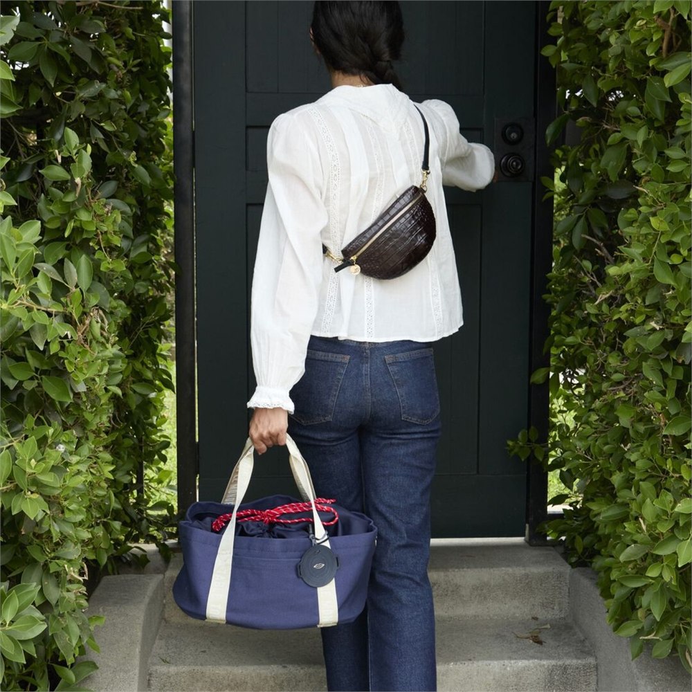 Full-size navy Dutch oven tote carried to a doorway