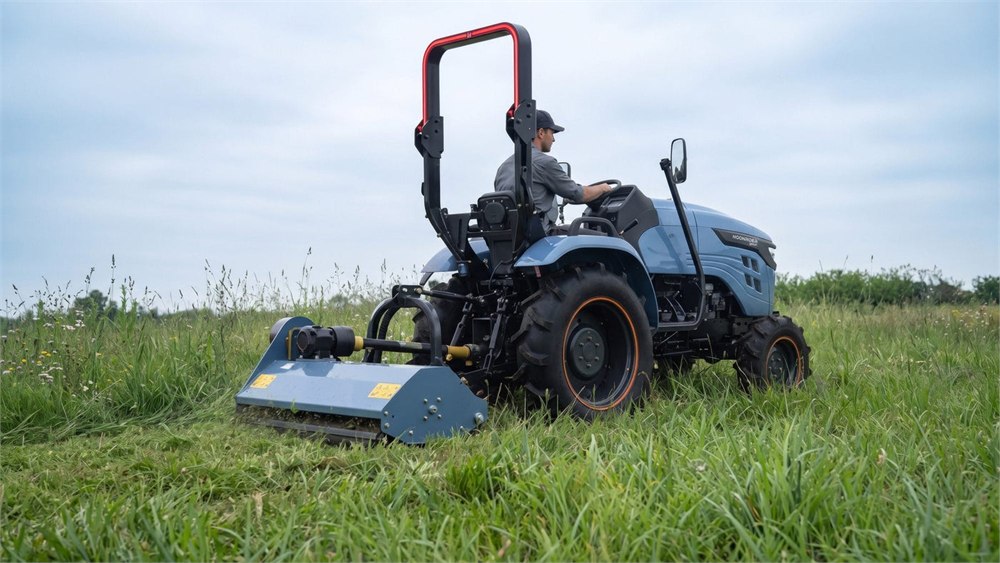 Electric tractor shown with a mower attachment