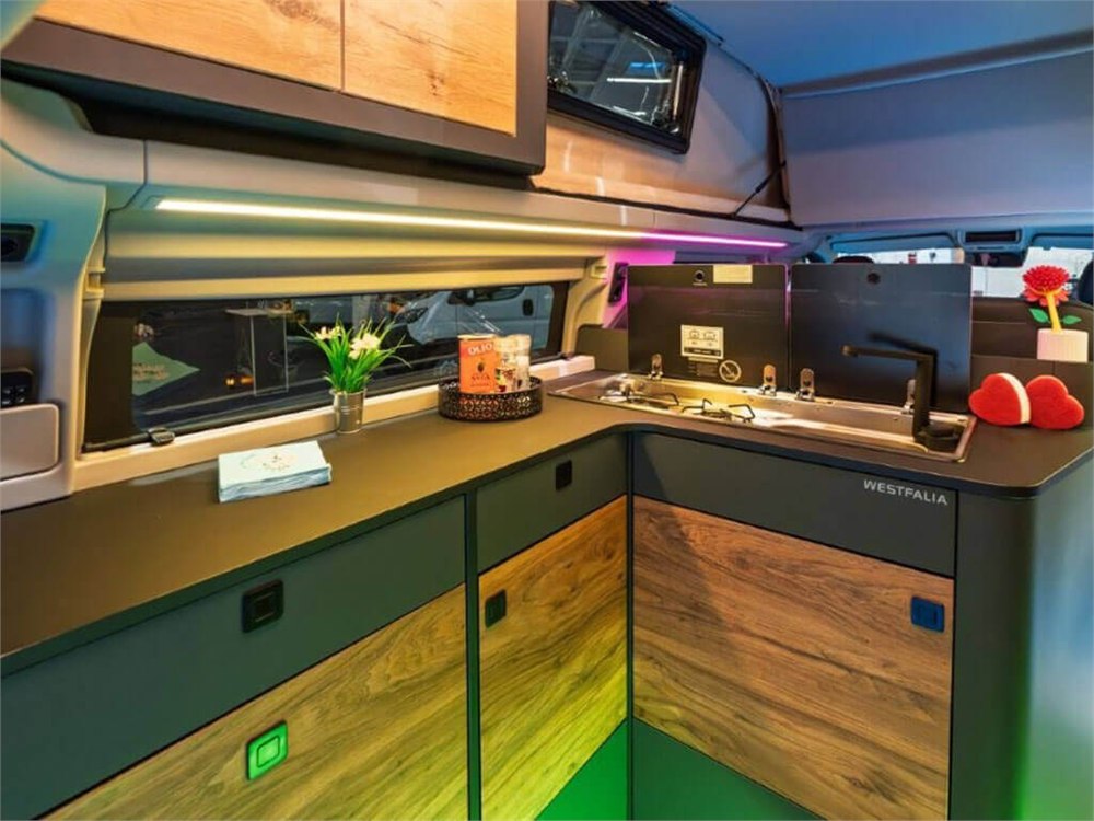 Rear L-shaped kitchen with wood-look cabinets in the display camper
