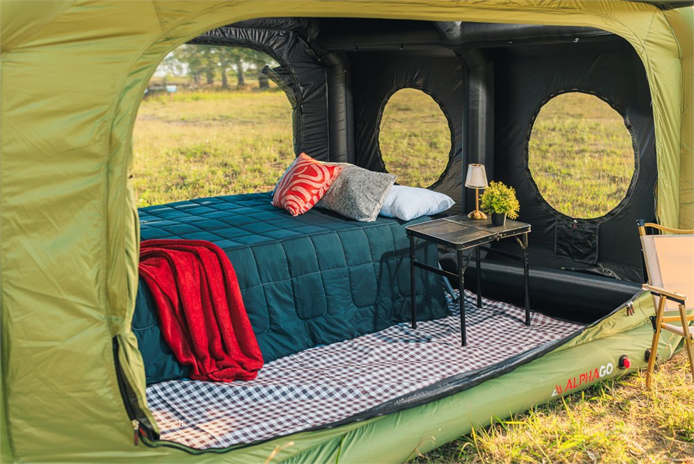 Green Cube tent styled with a bed and camp furniture