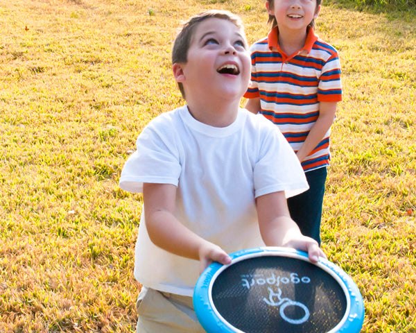 Kids playing outside with an OgoDisk Mini trampoline disk