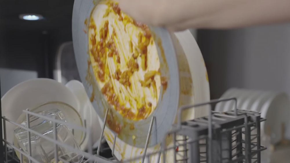 Dirty dish being loaded into the LISSOME R1 portable dishwasher