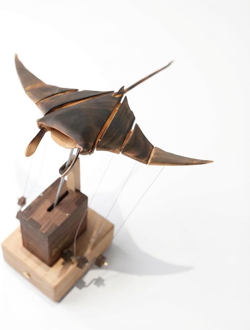 Wooden kinetic manta ray sculpture with segmented fins and exposed linkages
