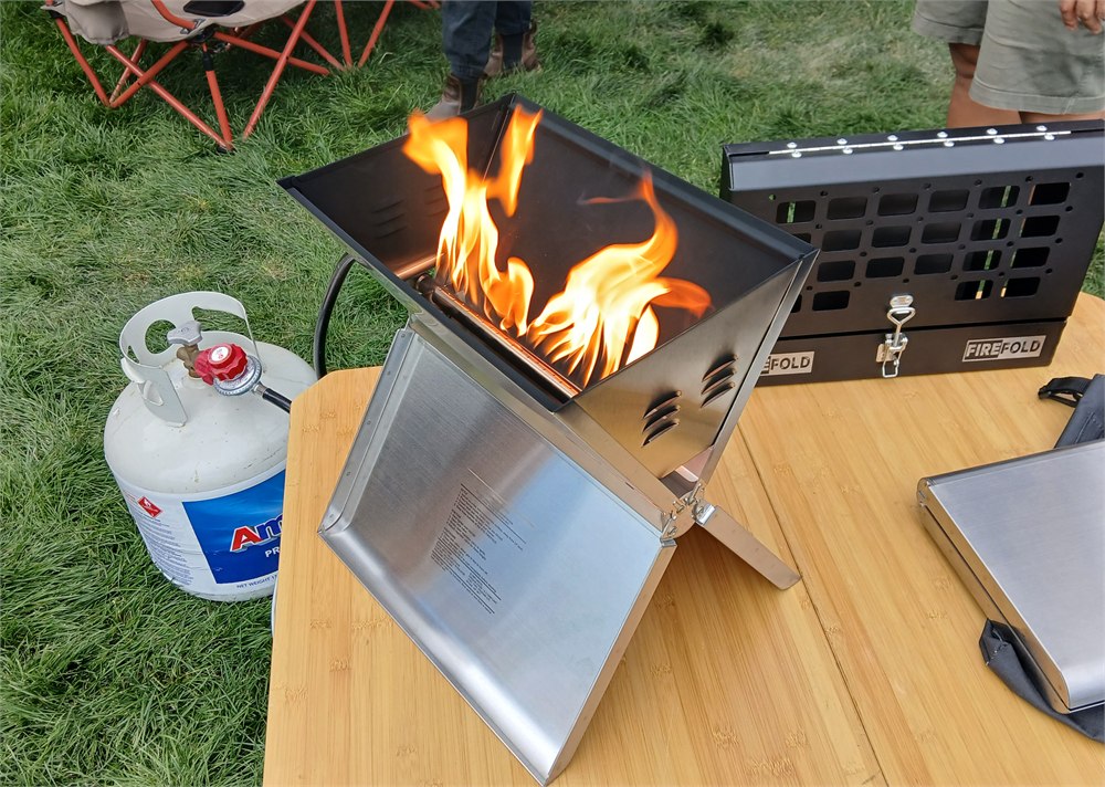 RTE FireFold open with flame and propane setup on a camp table