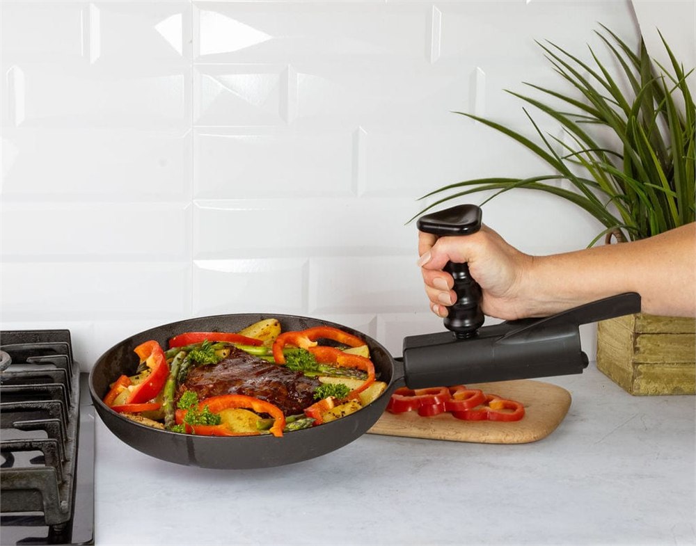 Pan Buddy attached to a skillet handle beside a stovetop