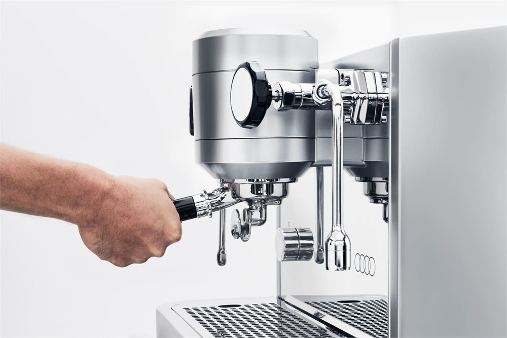 Hand holding the black portafilter handle