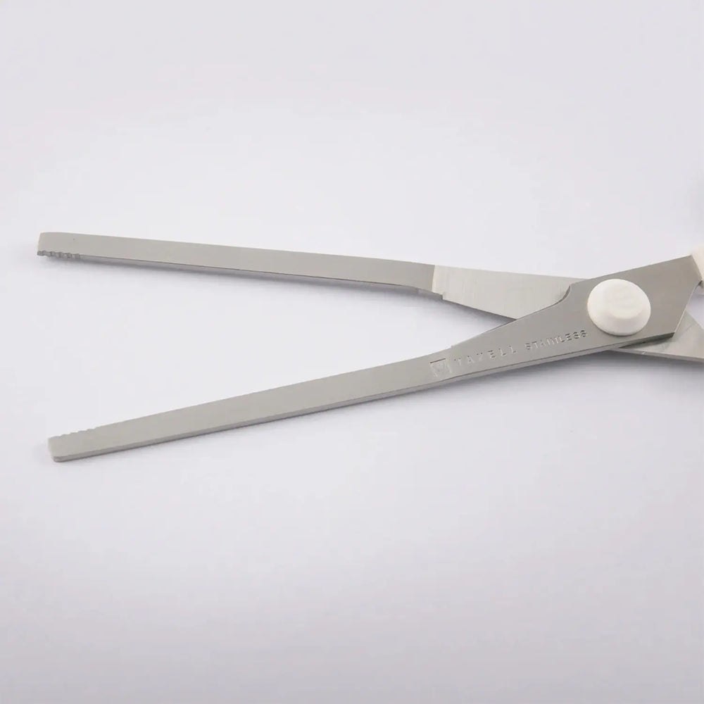 Long flat pressing blades and serrated tips of food pouch scissors