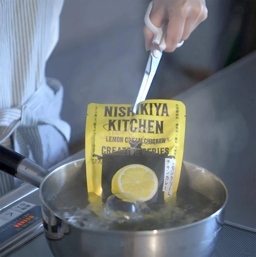 Yaxell gripping tips holding a food pouch above a saucepan