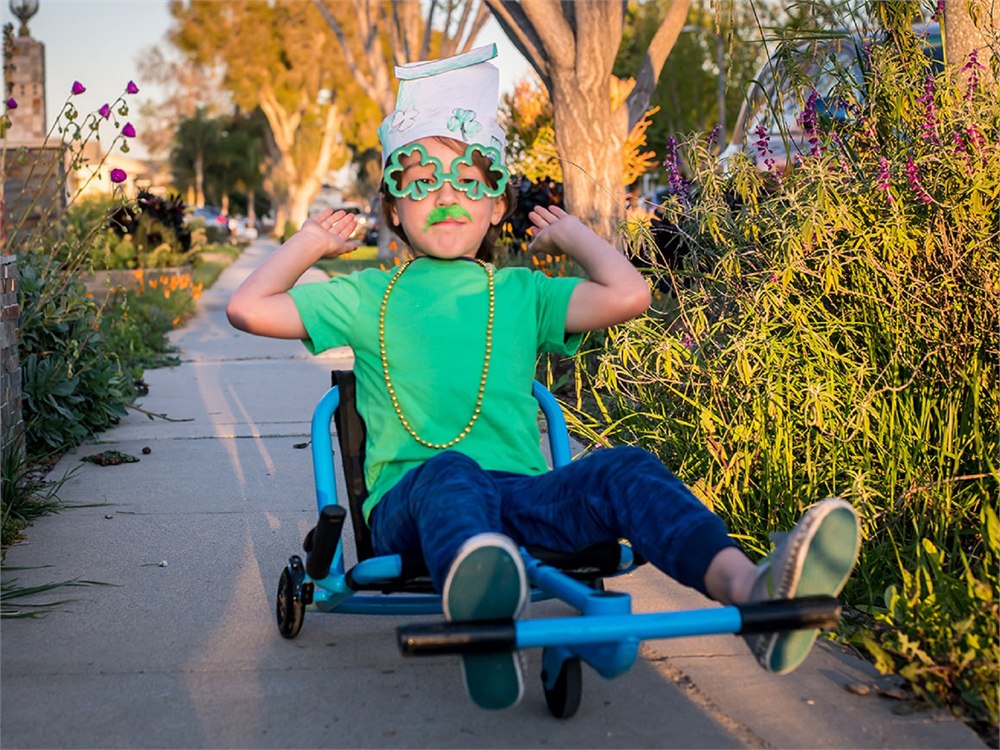 Child seated on a blue Classic with feet on the front bar