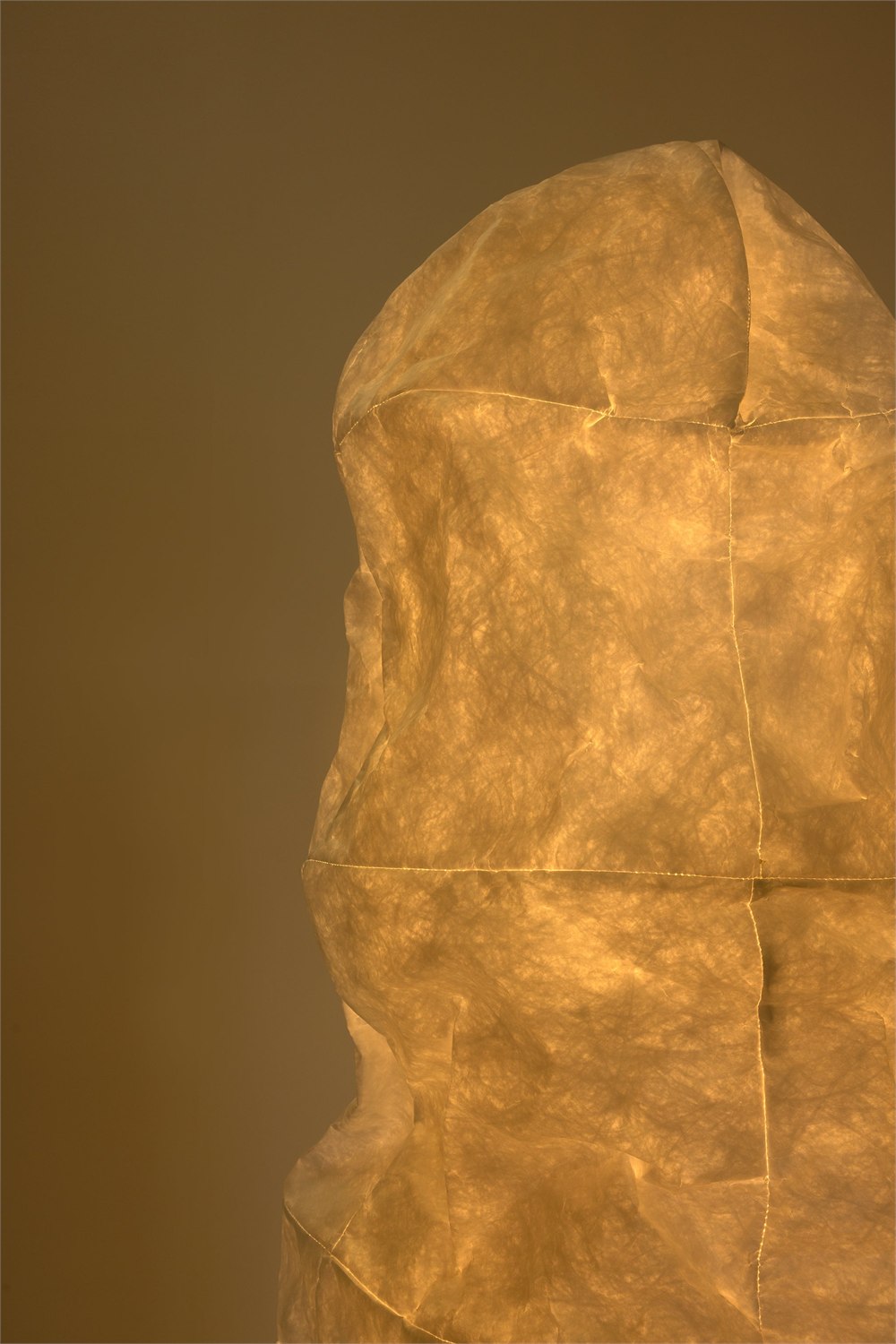 Illuminated shade showing seams and warm light through the textured surface