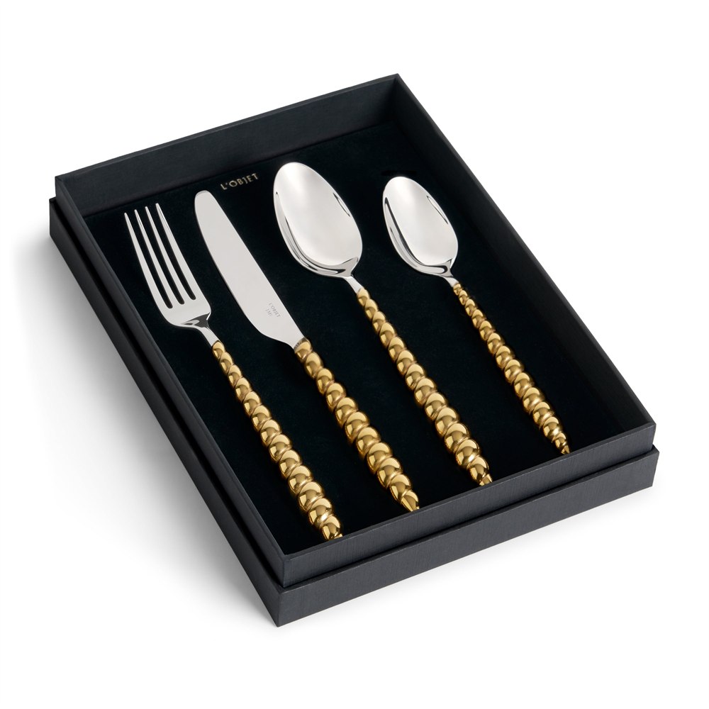 Four-piece gold shell flatware set in its presentation box