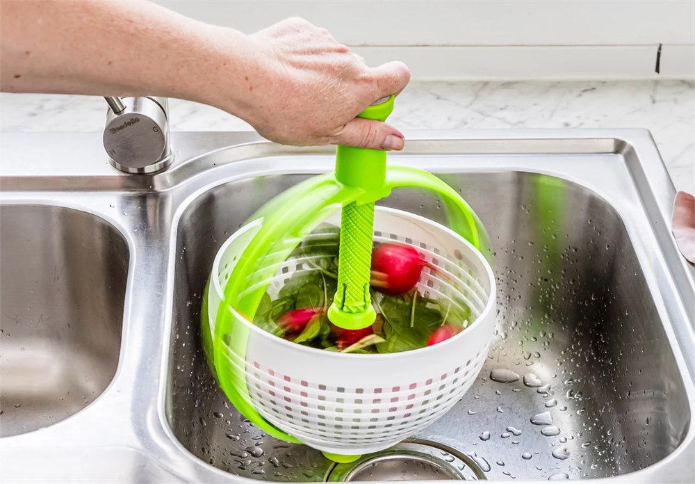 Spina spinning vegetables directly in a kitchen sink
