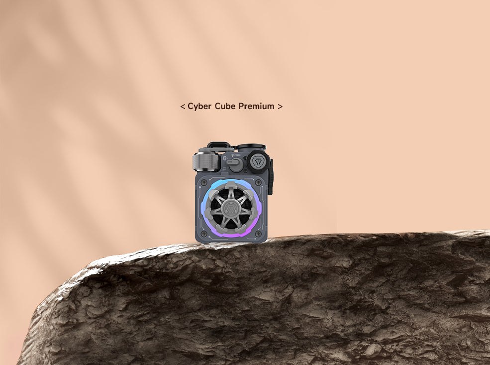Grey MUZEN Cyber Cube Premium speaker standing on a rocky ledge