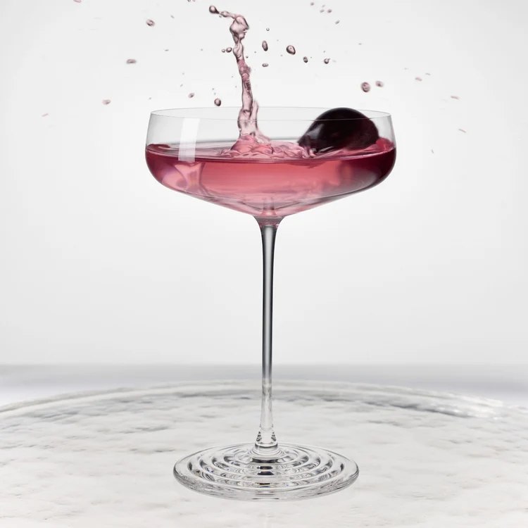 Splash coupe with pink liquid above its concentric glass foot