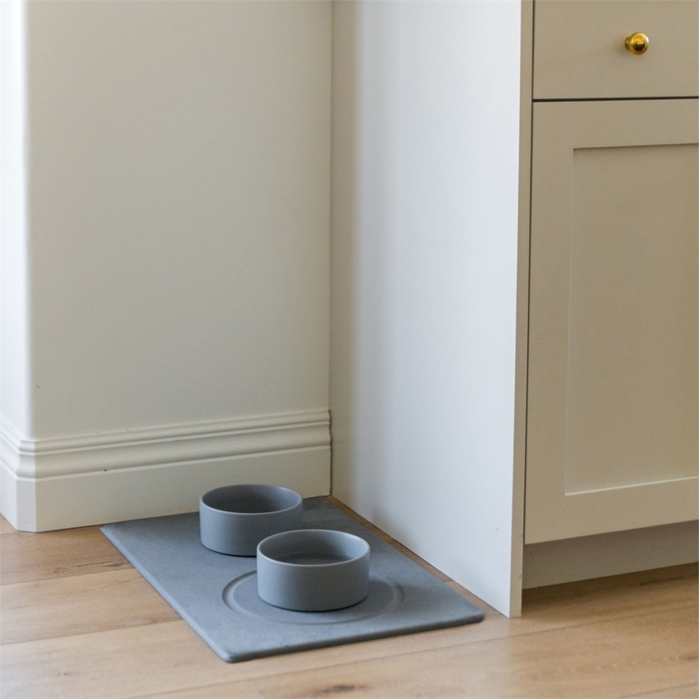 Stone dog bowl mat and bowls in a kitchen corner