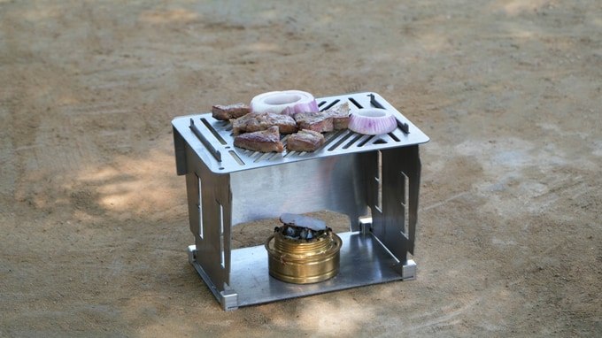 FlameMage titanium stove grilling meat and onions over an alcohol burner