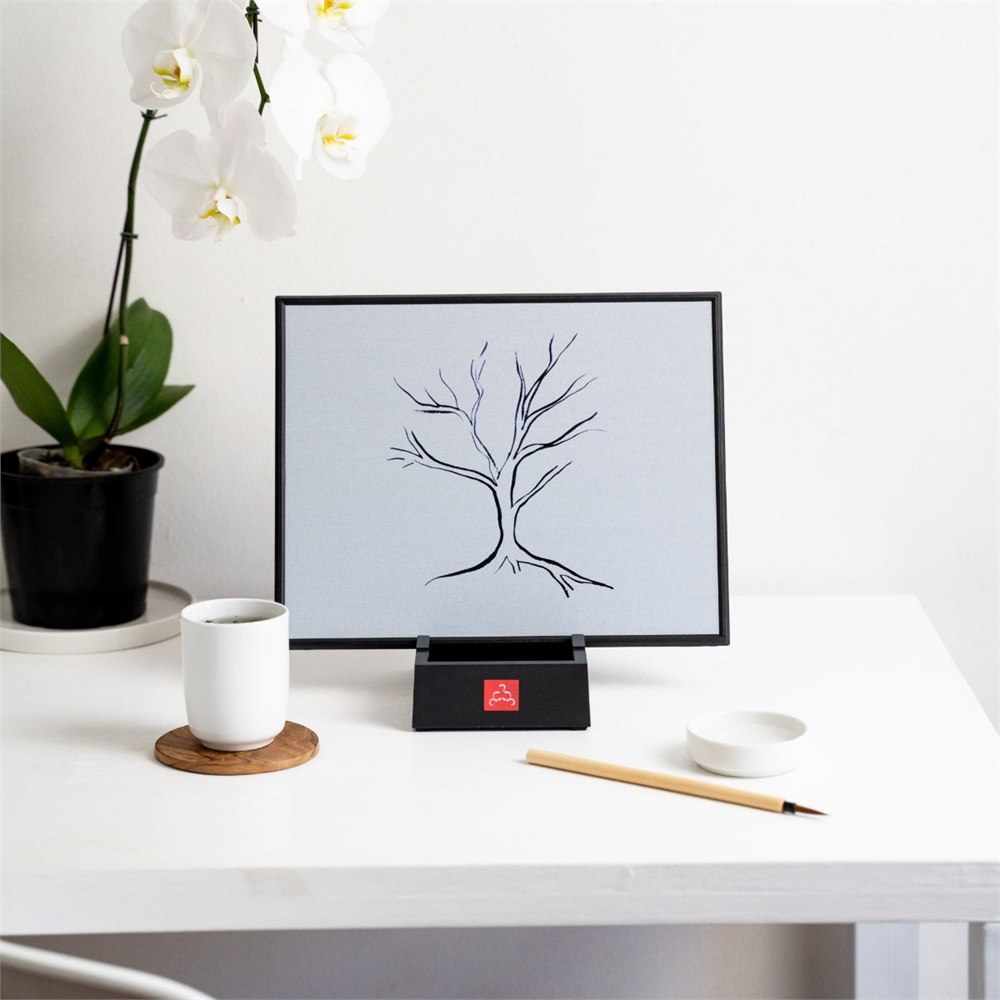 Buddha Board displaying a tree drawing on a home desk