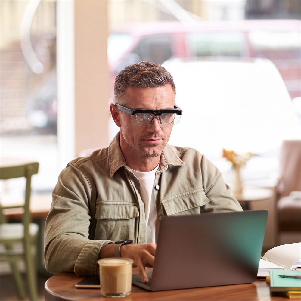 Person wearing VIVIFoCAL S1 glasses while using a laptop