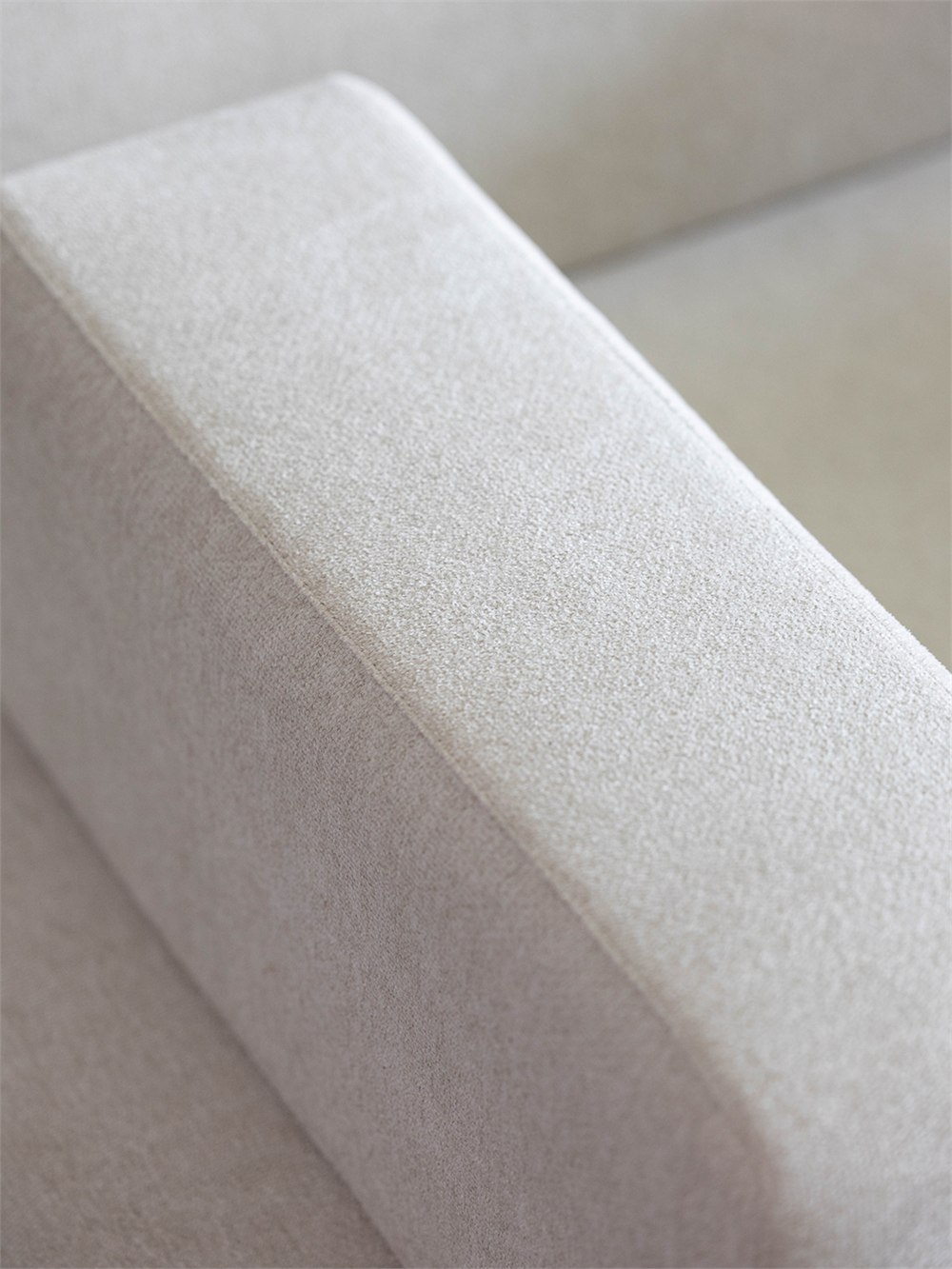 Close view of the Gyeolgu light upholstery and rounded arm