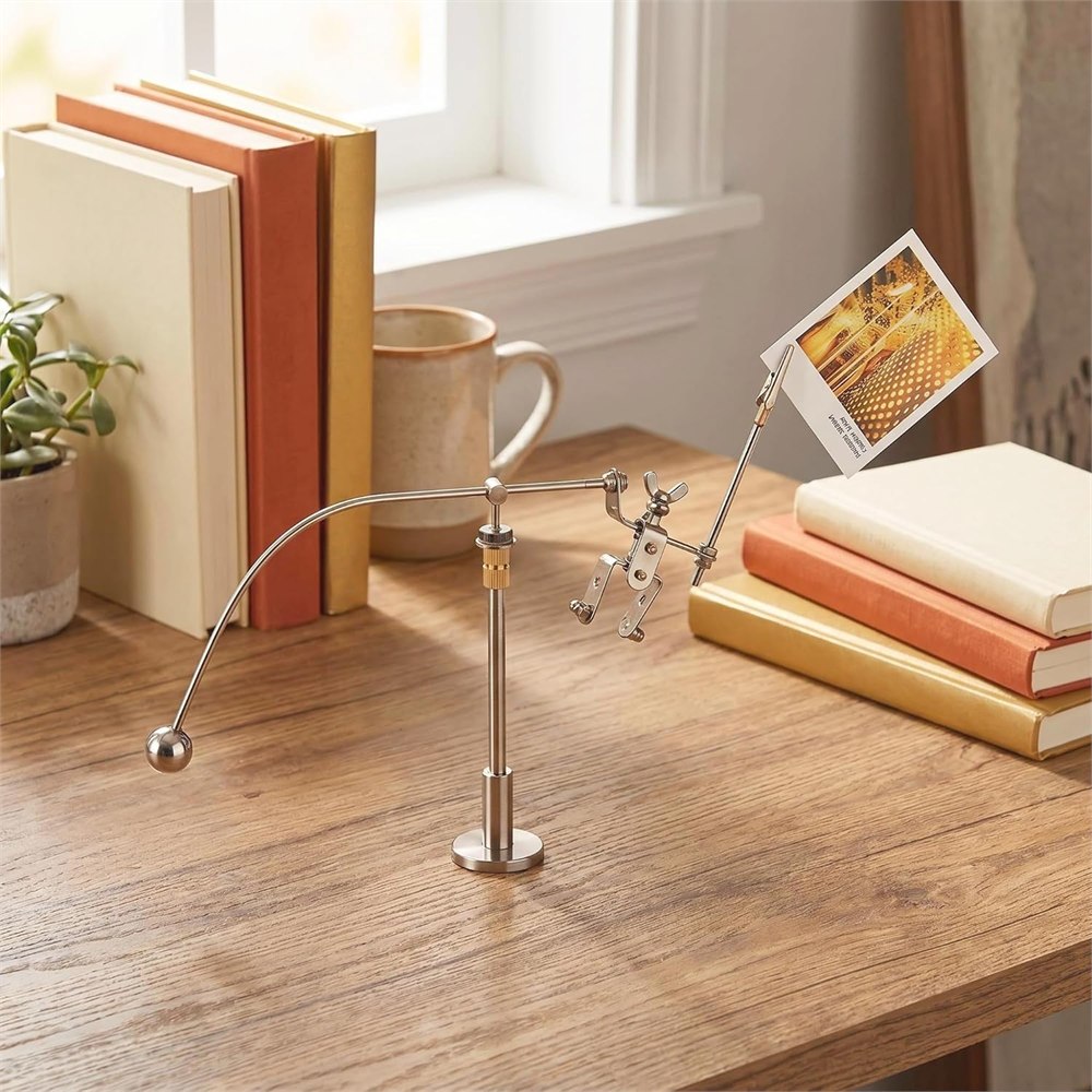 Robot memo holder displayed on a wooden desk beside books