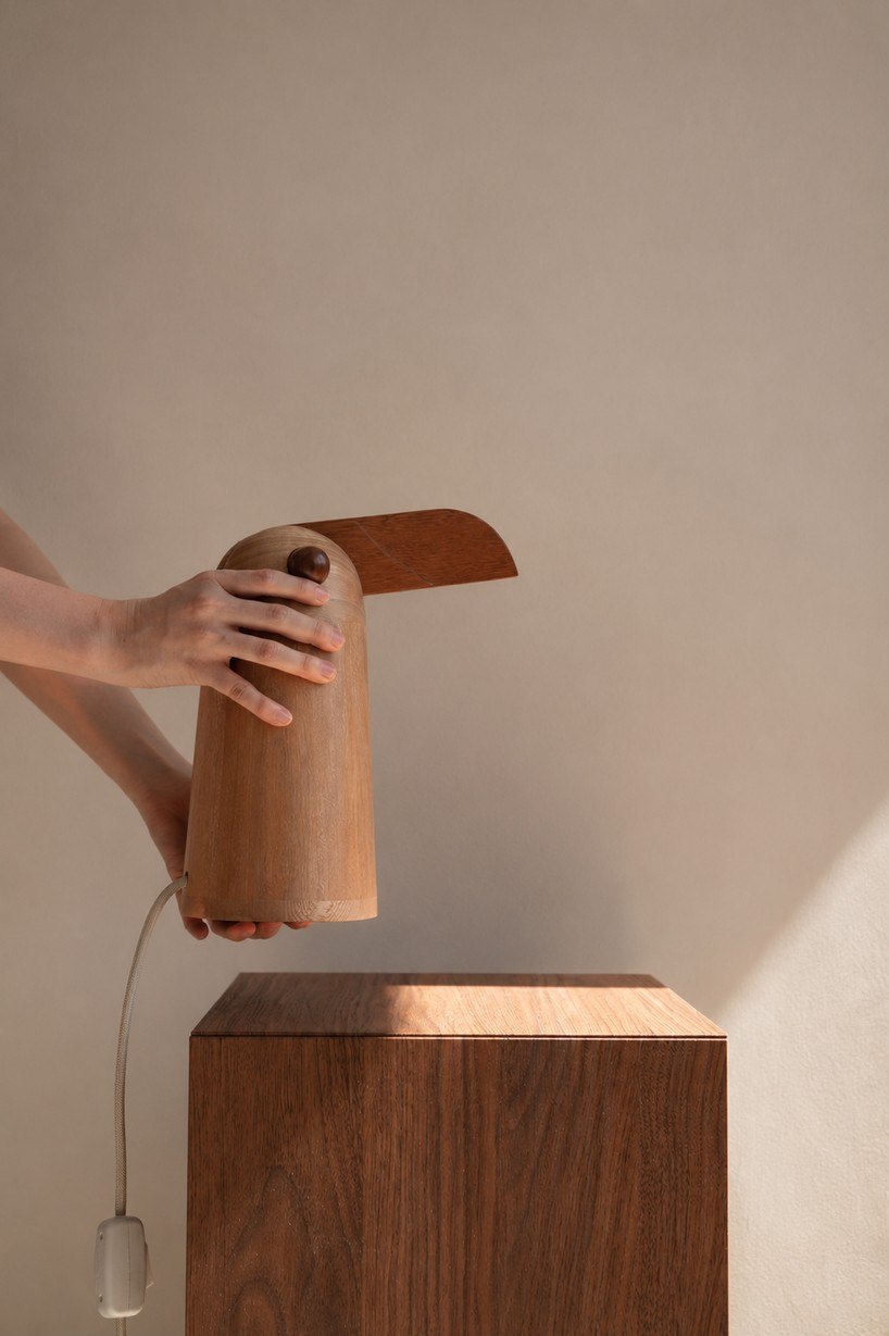 TUPI lamp held above a wooden cabinet showing its scale