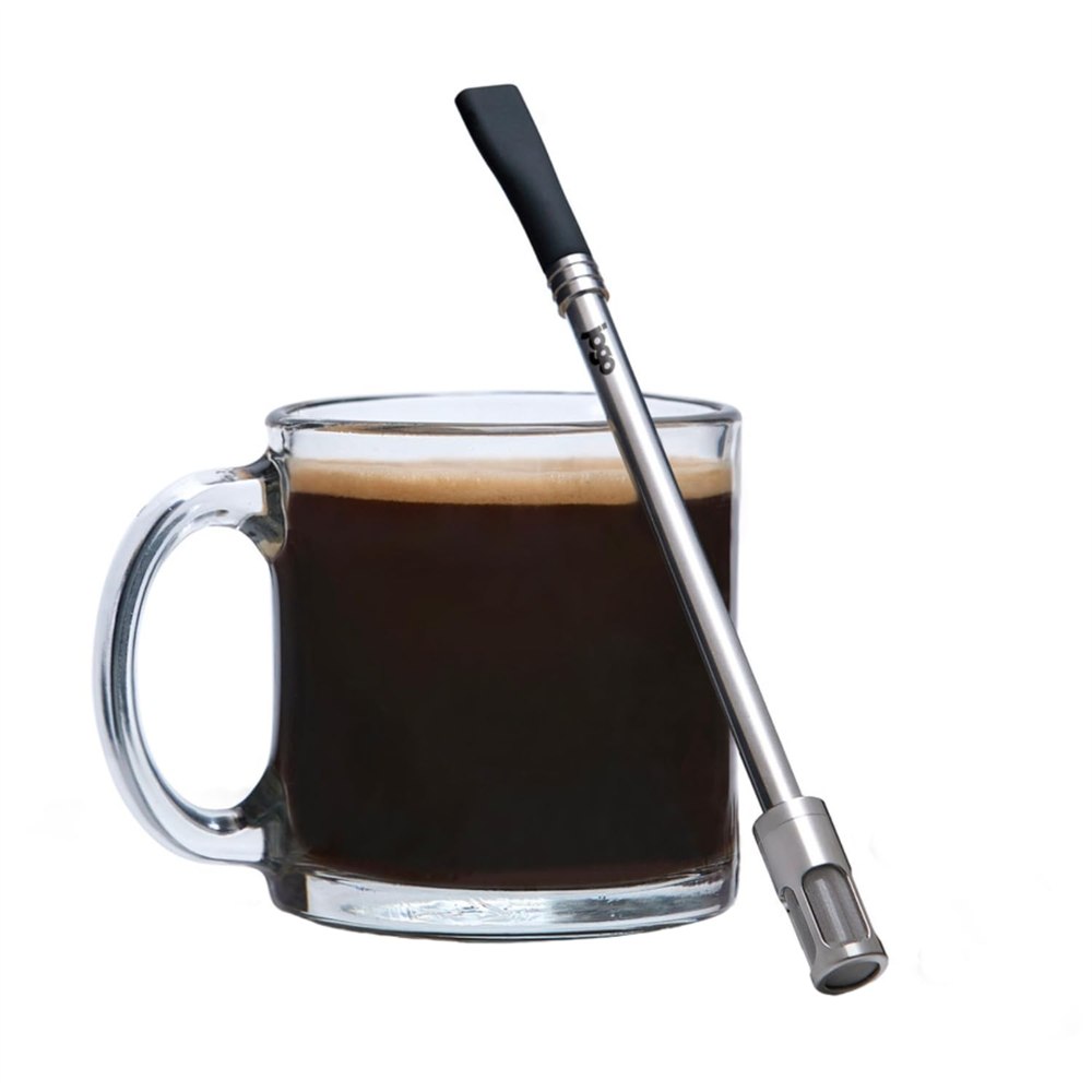 JoGo stainless steel brewing straw with silicone tip and mesh filter beside a coffee mug