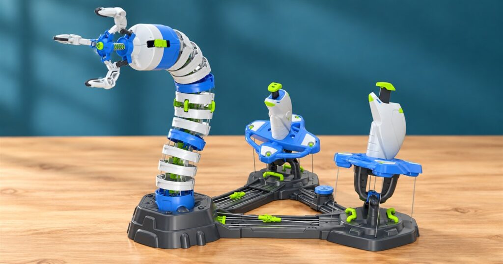 Cable-operated robotic arm kit with two joysticks on a desk