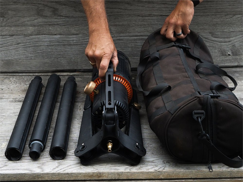 Camp Torch folded beside its carrying bag and removable poles