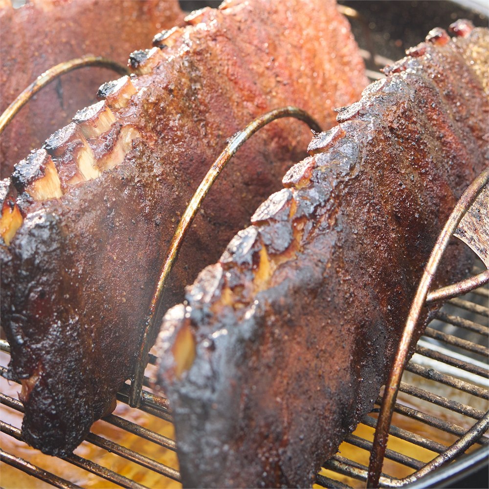 Food probes inserted into ribs cooking on a charcoal grill
