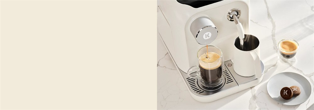 Keurig Alta brewing coffee beside its integrated milk pitcher