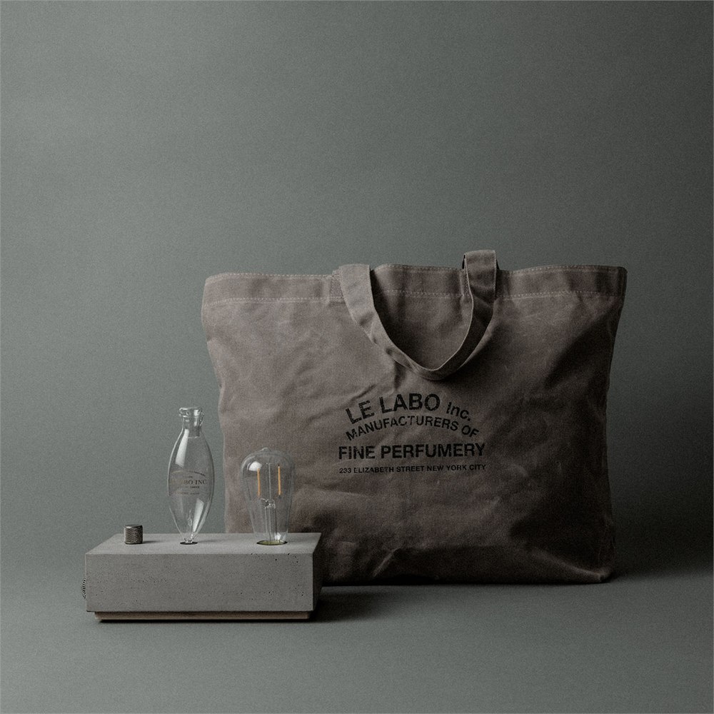 Le Labo concrete diffuser beside its waxed canvas tote bag