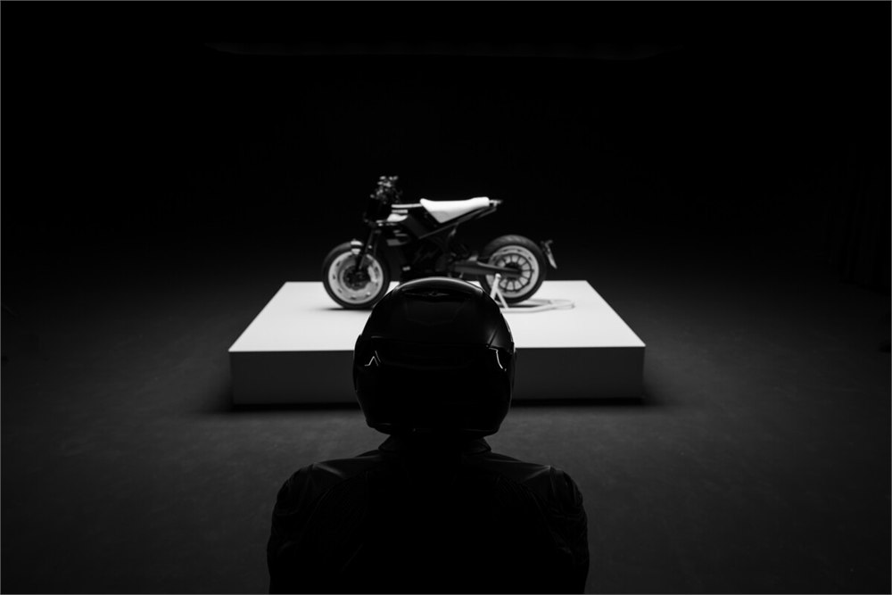 Motorcycle displayed on a platform with a helmeted rider in the foreground