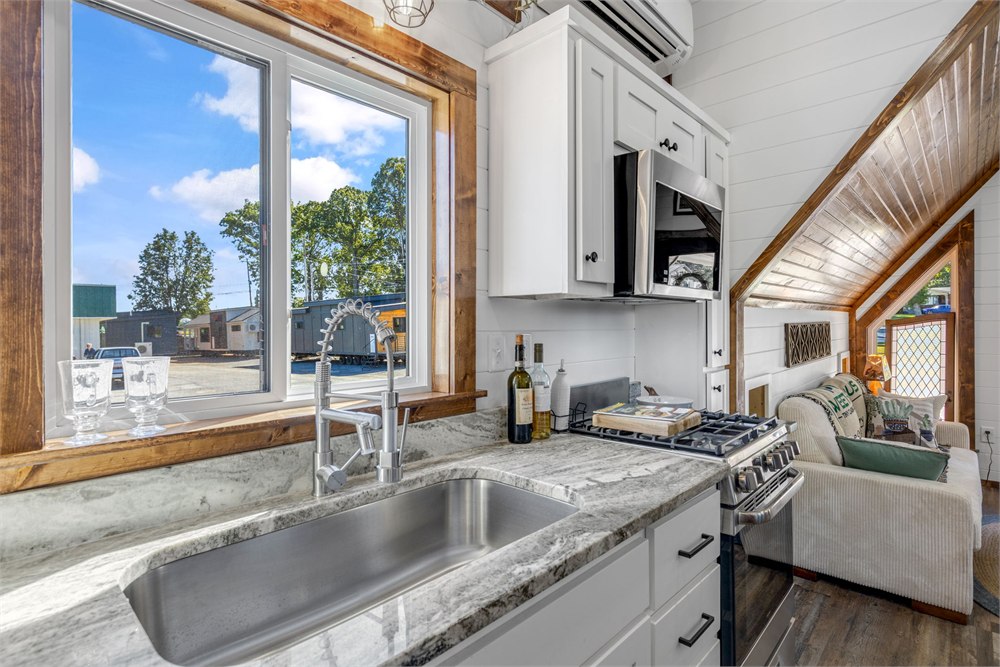 Tinde kitchen with granite counter sink cabinetry and range